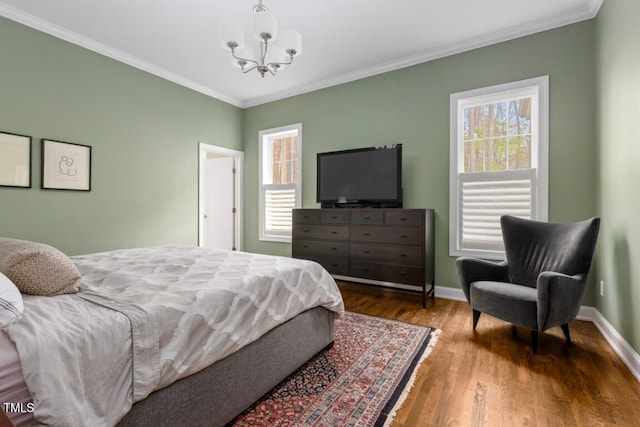 bedroom featuring multiple windows, hardwood / wood-style flooring, and ornamental molding