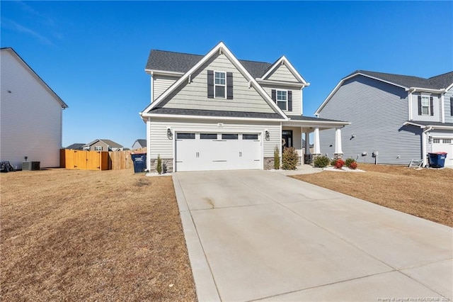 craftsman-style home with a garage, a front yard, and central air condition unit