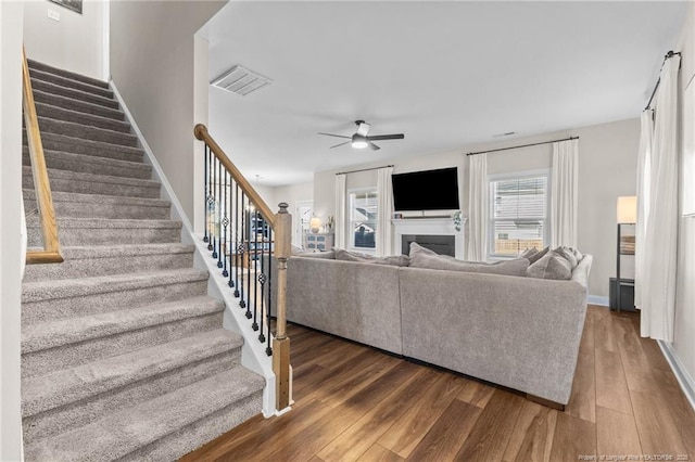 living room featuring ceiling fan and dark hardwood / wood-style flooring