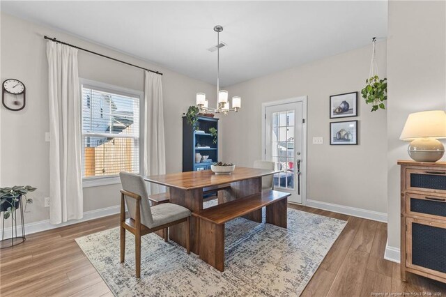 dining space featuring an inviting chandelier and light hardwood / wood-style floors