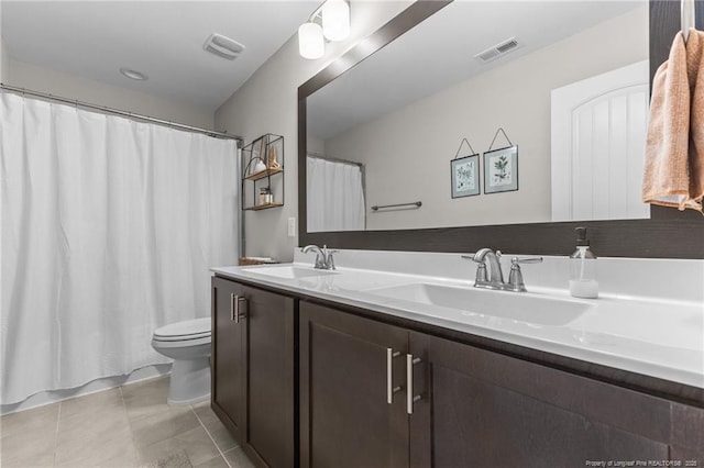 bathroom featuring vanity, tile patterned floors, and toilet