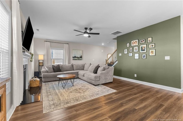 living room featuring wood-type flooring and ceiling fan