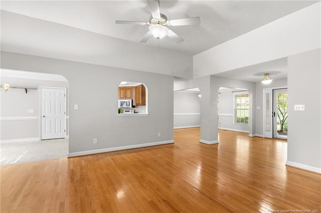 unfurnished living room featuring ceiling fan and light wood-type flooring