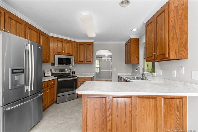 kitchen with an inviting chandelier, kitchen peninsula, appliances with stainless steel finishes, crown molding, and sink