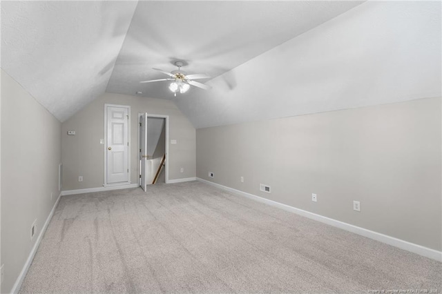 additional living space featuring ceiling fan, light colored carpet, and vaulted ceiling