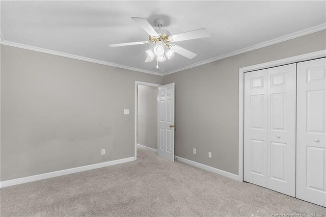 unfurnished bedroom featuring ceiling fan, light carpet, a closet, and crown molding