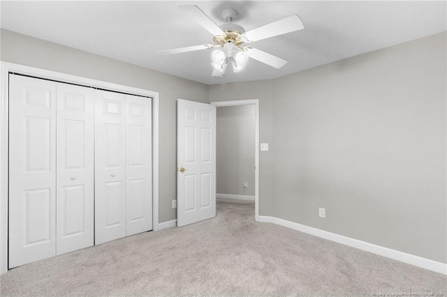 unfurnished bedroom featuring ceiling fan, light colored carpet, and a closet