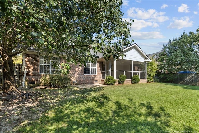 view of front of home with a front yard and a sunroom