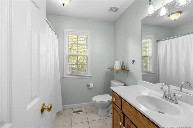 bathroom featuring toilet, a healthy amount of sunlight, vanity, and tile patterned floors