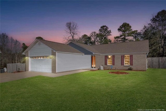 ranch-style house with a garage and a yard