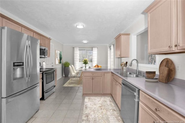 kitchen with appliances with stainless steel finishes, light brown cabinetry, kitchen peninsula, and sink