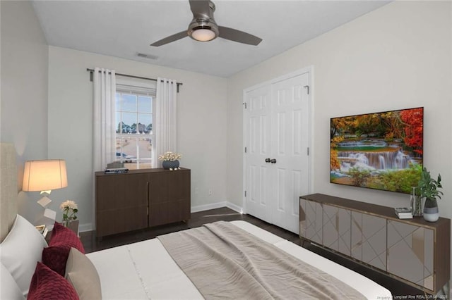 bedroom with a closet, dark hardwood / wood-style flooring, and ceiling fan