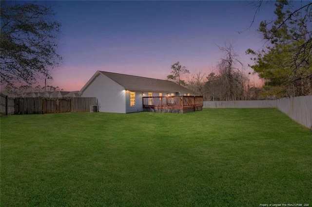 yard at dusk featuring a deck and cooling unit