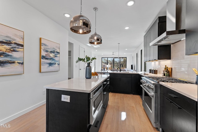 808 Culpepper Ln, Raleigh, NC 27610 - kitchen featuring hanging light fixtures, a center island, wall chimney range hood, and high end stainless steel range