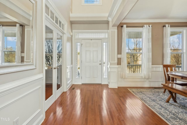 entrance foyer with crown molding and wood-type flooring