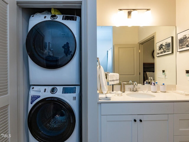 laundry area featuring stacked washing machine and dryer and a sink