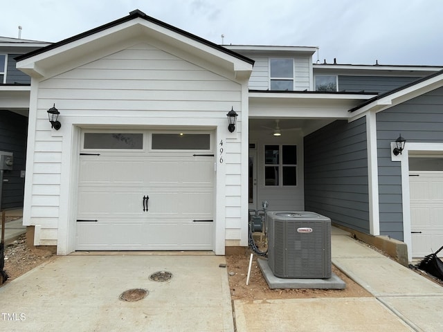 view of front of property featuring a garage, driveway, and central AC