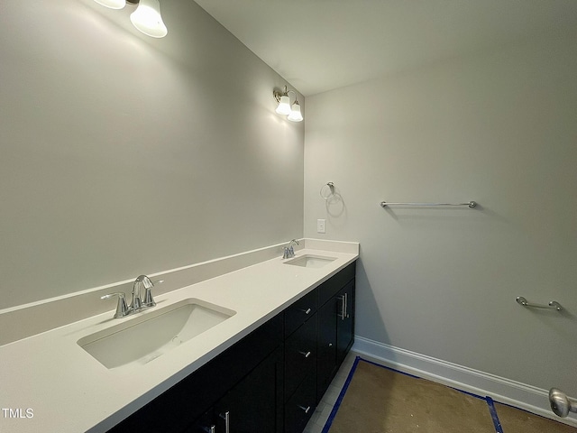 bathroom featuring double vanity, baseboards, and a sink