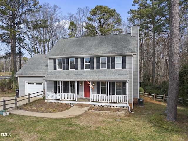 colonial inspired home featuring a garage, a front yard, central air condition unit, and covered porch