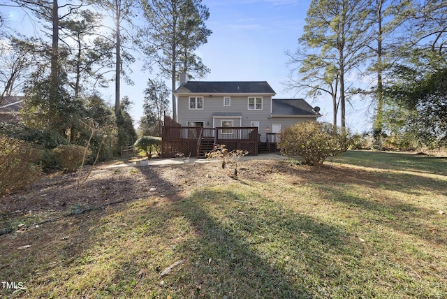 back of property featuring a wooden deck and a yard