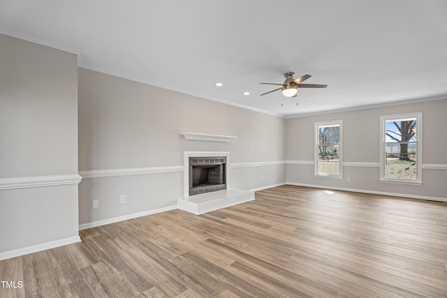 unfurnished living room with crown molding, ceiling fan, and light hardwood / wood-style flooring