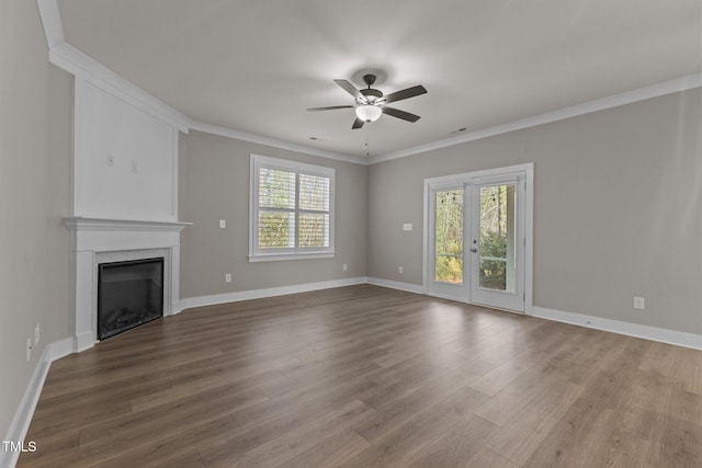 unfurnished living room with ceiling fan, wood-type flooring, ornamental molding, and a healthy amount of sunlight