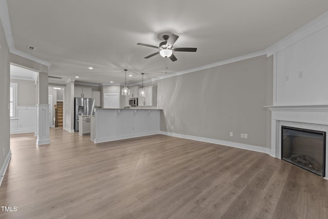 unfurnished living room with ceiling fan, light hardwood / wood-style floors, and ornamental molding