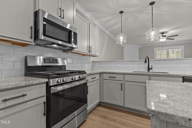 kitchen featuring light hardwood / wood-style floors, sink, stainless steel appliances, and tasteful backsplash