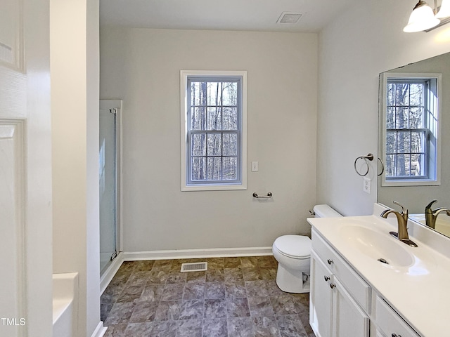 bathroom with a shower with shower door, vanity, plenty of natural light, and toilet