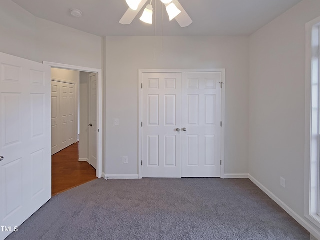 unfurnished bedroom featuring ceiling fan and dark carpet