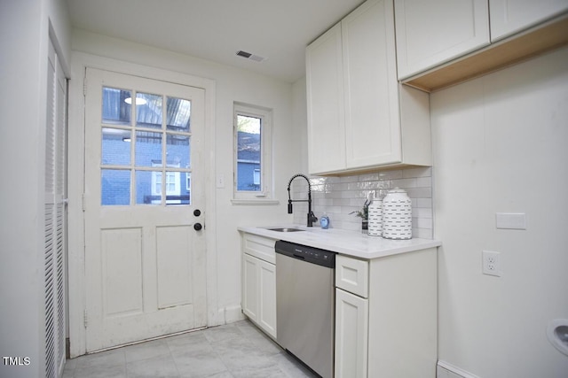 kitchen featuring tasteful backsplash, white cabinets, dishwasher, and sink