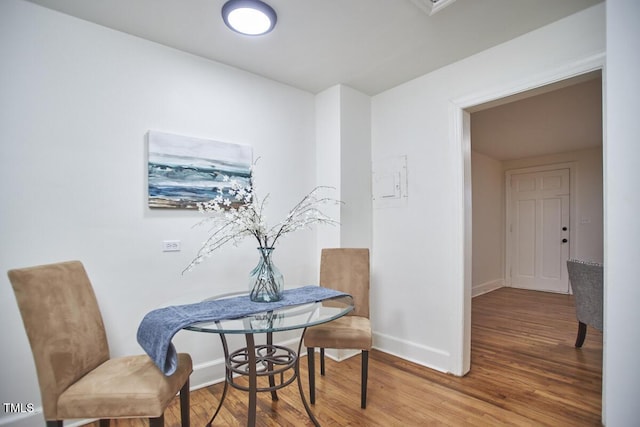 dining space with wood-type flooring