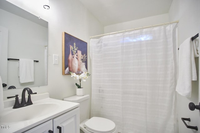 bathroom featuring toilet, vanity, and walk in shower