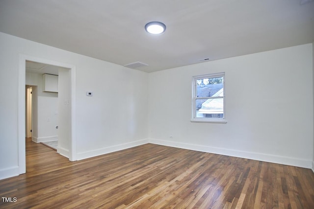 unfurnished room with dark hardwood / wood-style flooring