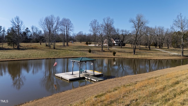 view of dock featuring a lawn and a water view