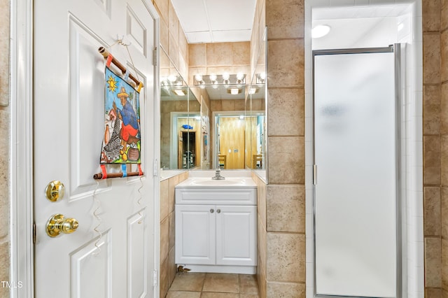 bathroom with vanity, tile walls, an enclosed shower, and tile patterned floors