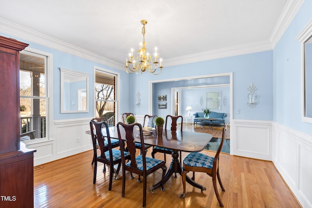 dining room with crown molding, light hardwood / wood-style floors, and a chandelier