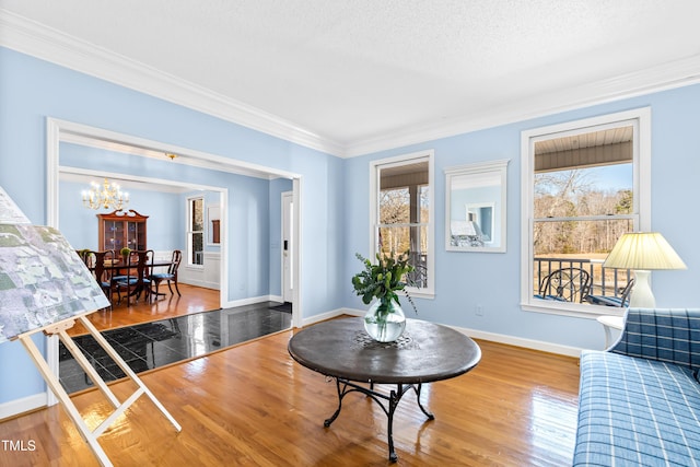 living room featuring an inviting chandelier, hardwood / wood-style floors, crown molding, and a textured ceiling