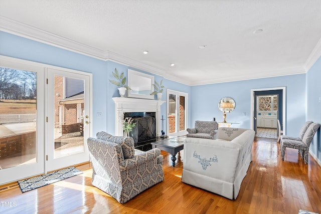 living room with crown molding and light hardwood / wood-style flooring