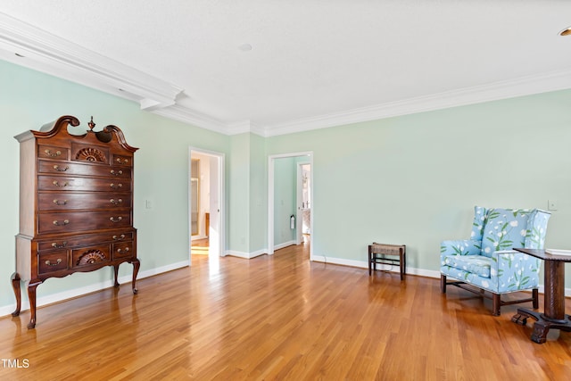 sitting room featuring crown molding and light hardwood / wood-style flooring