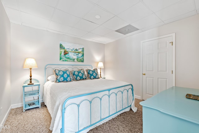 bedroom with carpet flooring and a drop ceiling
