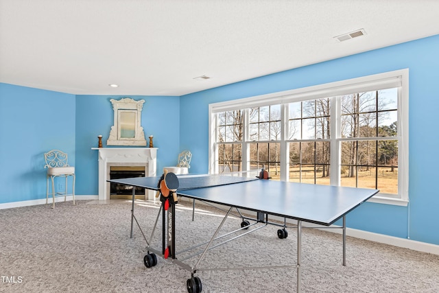 game room with a fireplace and carpet
