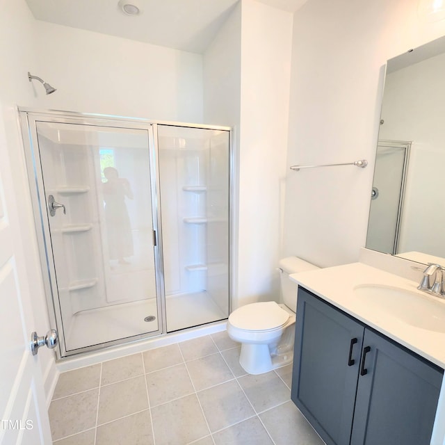 bathroom with an enclosed shower, vanity, toilet, and tile patterned flooring