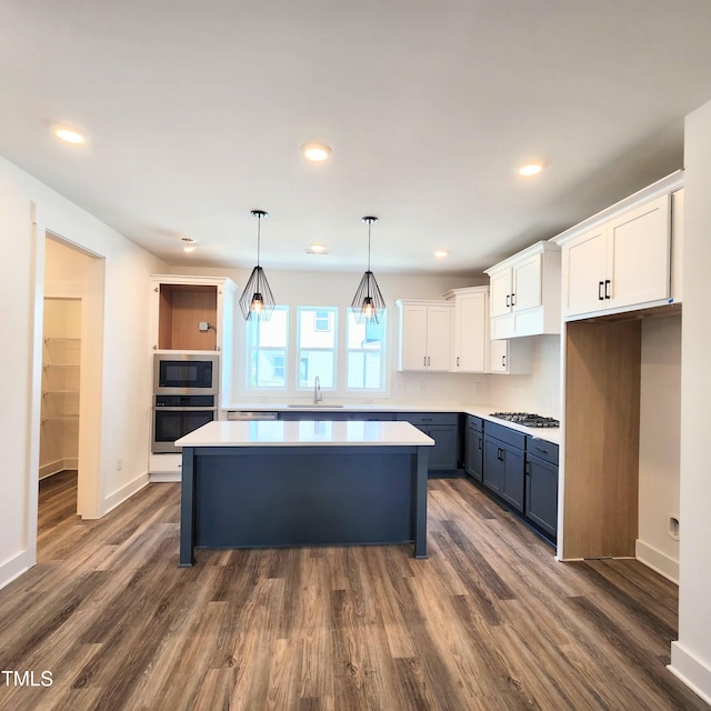 kitchen with white cabinets, a kitchen island, decorative light fixtures, dark hardwood / wood-style flooring, and blue cabinetry