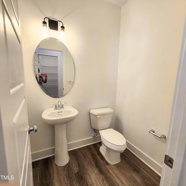 bathroom featuring toilet, sink, and hardwood / wood-style flooring