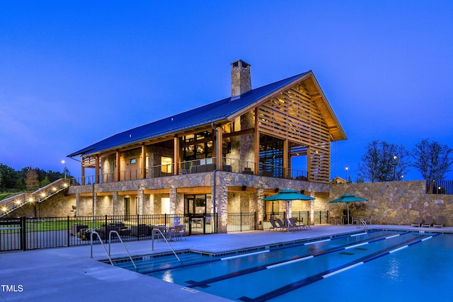 pool at dusk featuring a patio