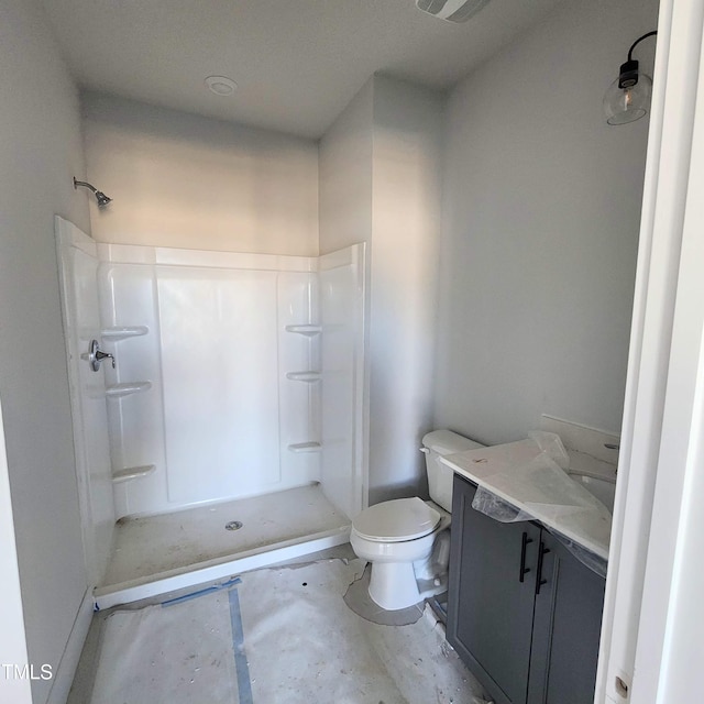 bathroom with toilet, vanity, and walk in shower