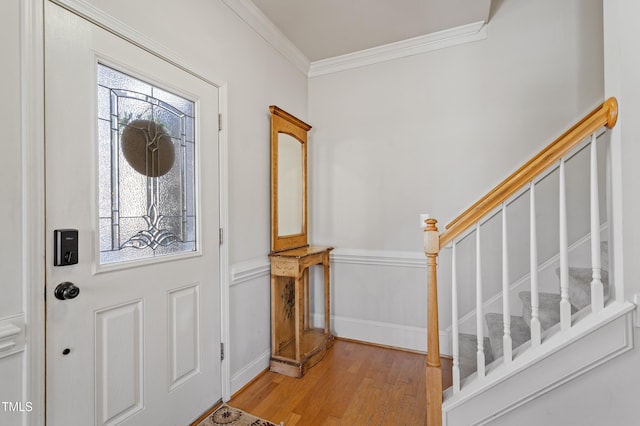 entryway with crown molding and light hardwood / wood-style floors