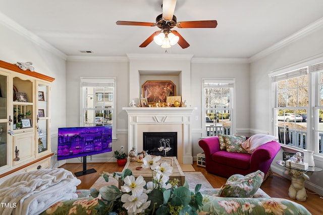 living room featuring ceiling fan, crown molding, and light hardwood / wood-style floors