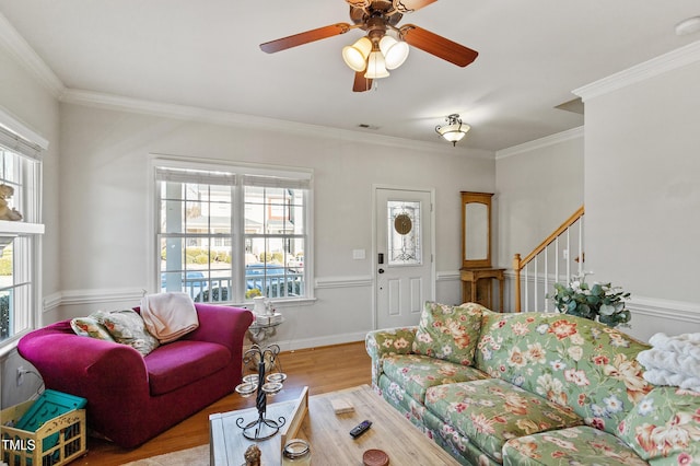 living room featuring ceiling fan, light wood-type flooring, plenty of natural light, and crown molding